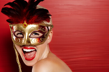 Portrait, excited and woman in carnival mask for fun, art deco and dress up by red background. Happiness, female person and mysterious or playful with wow emoji for mockup in studio with lipstick