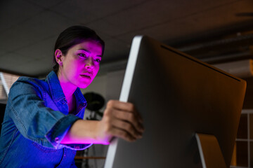 Young businesswoman examining computer screen in office