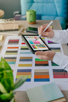 Interior designer working on color swatches over tablet PC at desk in office