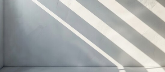 Shadow and stripes create a striking diagonal pattern on a white wall with sunlight peeking through, resulting in a dynamic architectural design effect.
