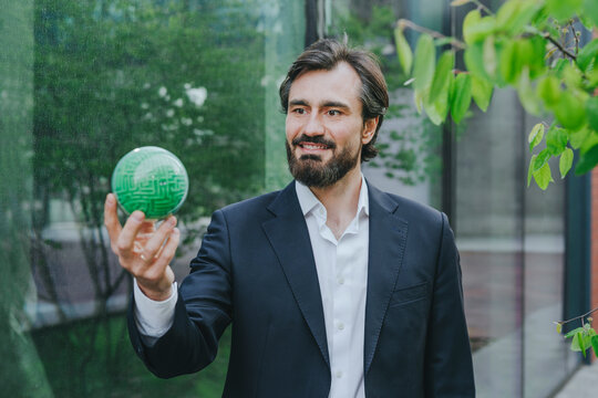 Businessman holding puzzle sphere near office building
