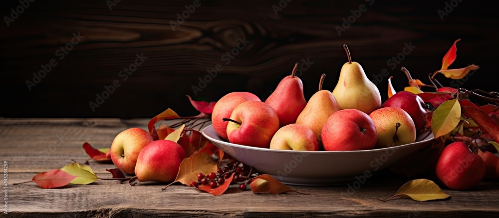Poster On a wooden table a clay plate displays ripe pears and red paradise apples Fallen leaves scatter around the plate creating a picturesque scene Ample copy space is available for additional elements