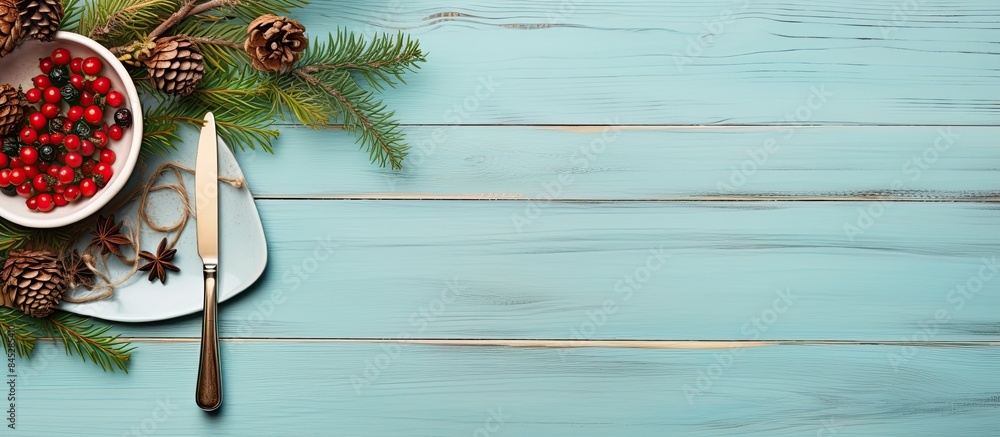 Aufkleber A festive Christmas table with a menu arrangement adorned with pine tree branches and spices The table is set on a light blue or green wooden background made of fir twigs cones and berries It is pres