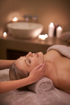 Face massage, spa and relax with woman, beauty and candles with hospitality and stress relief. Person, facial and girl with wellness or healthy with vacation or peace with holiday, detox or self care