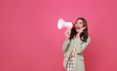 Young Asian teen woman holding megaphone announce discount isolated on pink copy space background....