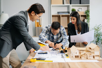 Engineer teams meeting working together wear worker helmets hardhat with on architectural project site and making model house. Asian industry professional team
