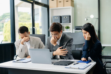 Furious two Asian businesspeople arguing strongly after making a mistake at work in panic after company bankruptcy concept