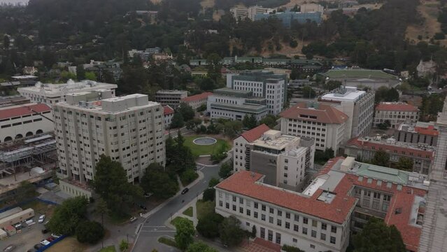 alt aerial view of UC Berkeley campus flying backward past Campanile tower