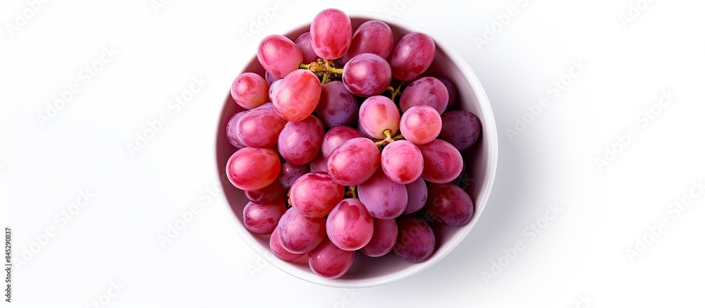Poster The image shows a top view of a bowl filled with pink grapes Kishmish The grapes are isolated on a white background and there is copy space available for text The set captures the grapes from various