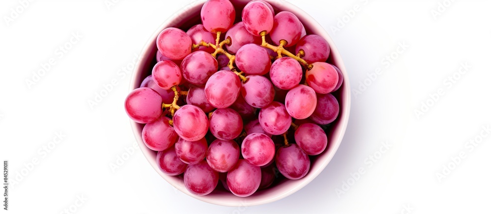 Poster The image shows a top view of a bowl filled with pink grapes Kishmish The grapes are isolated on a white background and there is copy space available for text The set captures the grapes from various