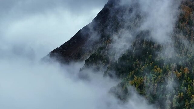 Swiss Alps Saas Fee Saastal Switzerland aerial drone flight parallax zoom larch forest fog mountain alpine valley glacier gondola rainy foggy mist grey clouds wet fall autumn forward circle left