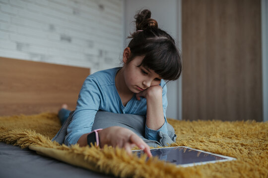 Young schoolgirl struggling with learning at home, doing homework. Learning difficulties in children