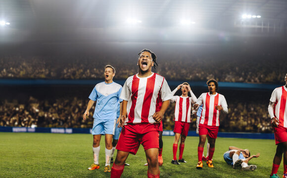 Professional football players reacting passionately during a match in a stadium