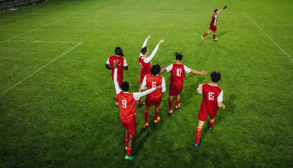 Professional football players celebrating a goal on the field during a championship match