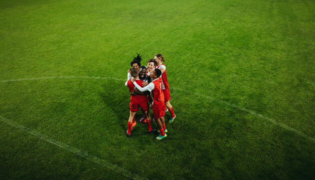 Football team celebrating victory on the field during a match
