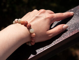 Elegancka bransoletka z kamieni naturalnych na kobiecej dłoni w słońcu © Anna