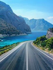 Empty highway between mountain peaks, sea coast on one side of the road, blue water, clear sunny day, incredible nature, bright saturated colors