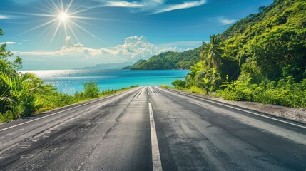Empty highway, dense tropical forest on one side of the road and sea coast on the other, blue water, clear sunny day, bright rays, incredible nature