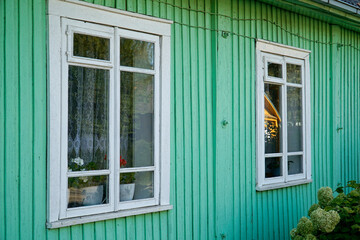 Traditional wooden Karaim house painted green - close-up on windows - Trakai, Lithuania