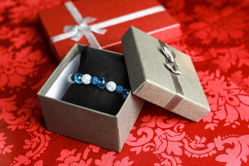 Bransoletka z kryształu górskiego, niebieskiego kryształu i jadeitu. Biżuteria w szarym pudełku © Anna