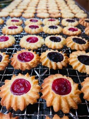Marmeladenplätzchen mit roter und lila Füllung auf einem Abkühlgitter