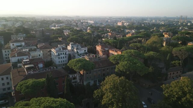 Establishing dolly above trees to old historic white brick buildings of Orange Garden Rome Italy