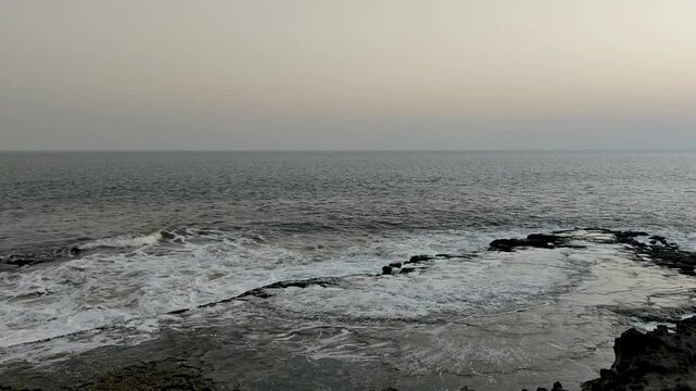 Waves hitting the sea shore in slow motion and splashing water. Evening, full HD
