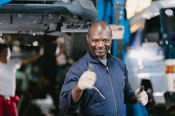 Portrait Happy Garage Mechanic African Black male smiling thumbs up looking camera.