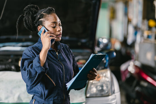 Garage women worker technician manager talking phone call with customer for service information.
