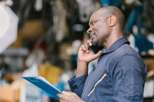 Garage male worker technician manager talking phone call with customer for service information. - Powered by Adobe