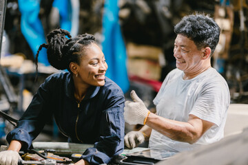 Engineer team working together helping fix service broken car. Women mechanic training in Garage workshop.