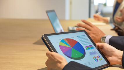 Business people having a meeting while looking at a tablet screen