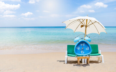 Blue alarm clock with beach chair on tropical beach, outdoor day light, it's summer time, time for...