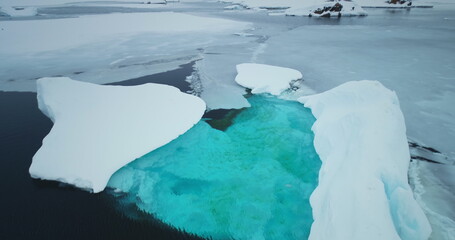 Melting iceberg blue water drifts frozen icy ocean in Antarctica. Towering glacier in snowy...