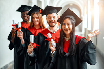 Graduates celebrating academic achievement with diplomas at university ceremony