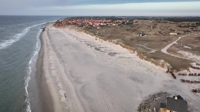  North Sea coastal landscapes, sandy shore and rhythmic movement of waves from above.Dune landscape with view to the village of Gammel Skagen. Footage of house at the beach Fellen near Gammel Skagen. 