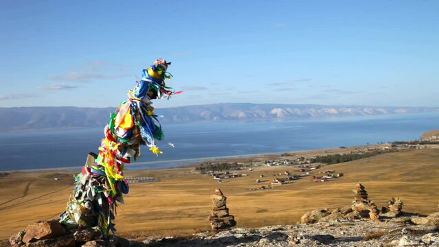 Video of Baikal Lake on Autumn. Olkhon Island. Top view of Small Sea and Khuzhir village from sacred place with stone pyramides and Serge pillar with colorful ribbons. Travel and outdoors recreation