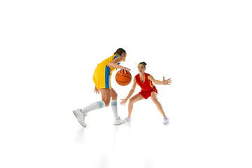 Defensive Stance. Dynamic image of competitive young women in motion, training basketball isolated on white studio background. Concept of sport, active lifestyle, competition, game, dynamics