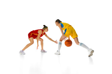Dynamic Duel. Young women, basketball athletes in yellow and red uniforms in motion during training...