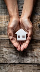 Hands holding a small white model of a house