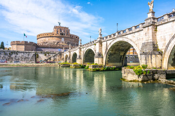 The iconic SantAngelo Bridge and Castel in Rome are reflected on a sunny day, showing the citys historic architecture