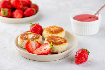 Cheesecakes, syrniki, cheese pancakes with berries, jam, cashew, and tofu on a table. Sugar, lactose and gluten free.