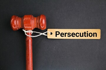 judge's hammer and a paper tag with the word persecution