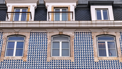 Windows in a tile-covered wall in Lisbon, Portugal