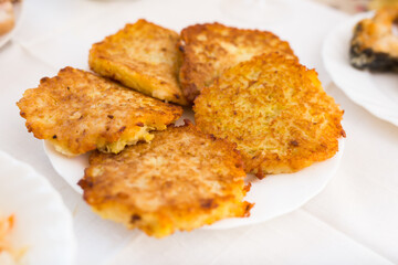 Potato pancakes with sour cream on white plate