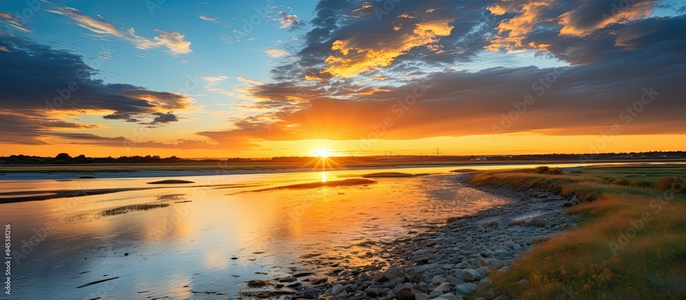 Aufkleber yellow sunset where the river flows into the sea there are low blue clouds in the sky. creative bann