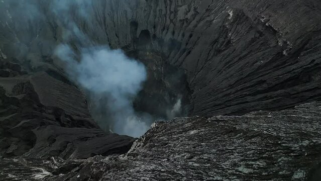 Aerial view flying to mount active volcano cloudy Bromo crater