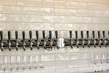 Row of taps in a wine bar for dispensing different types of wine by the glass