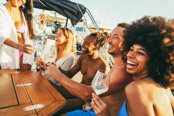 Multiracial friends having fun at boat party during summer vacation - Happy people cheering with...
