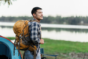 Adventurous Traveler with Backpack Enjoying Scenic Lake View at Campsite - Ideal for Travel,...